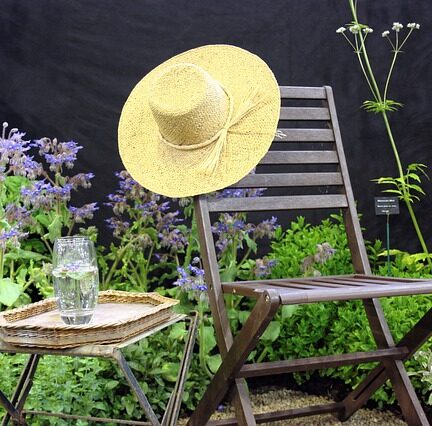chapeau de paille sur chaise de jardin
